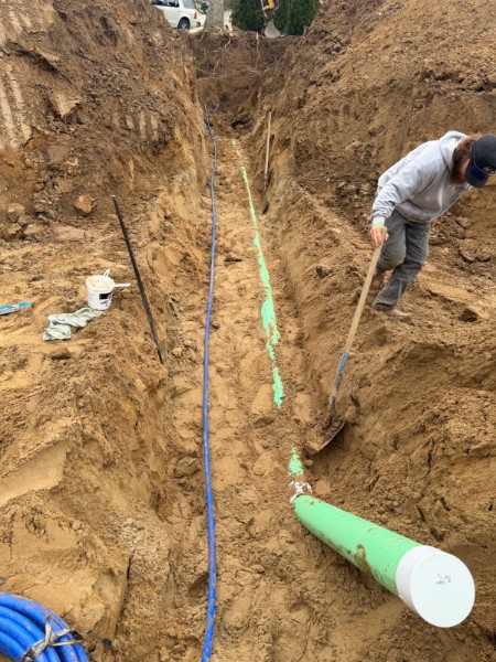 Green utility conduit placed in a narrow trench