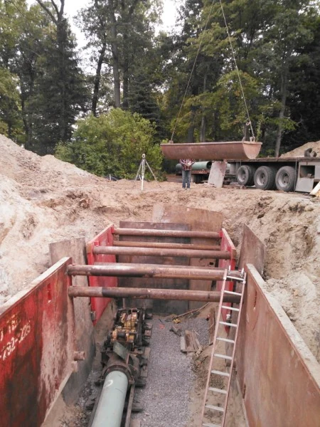 Deep shored utility excavation with a crew working below grade